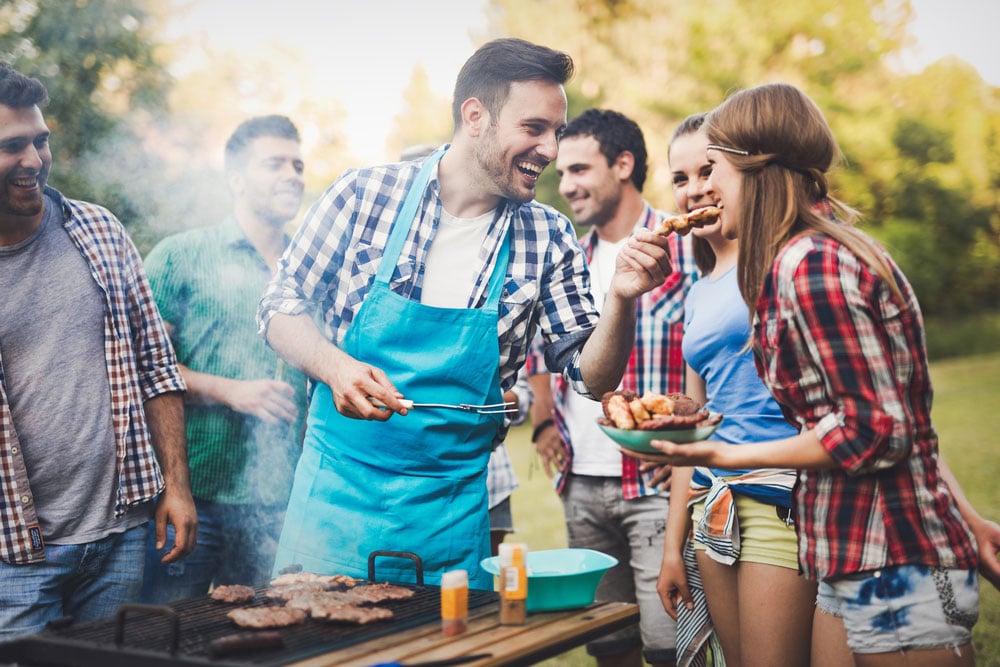 Friends having a barbecue party in nature while having a blast
